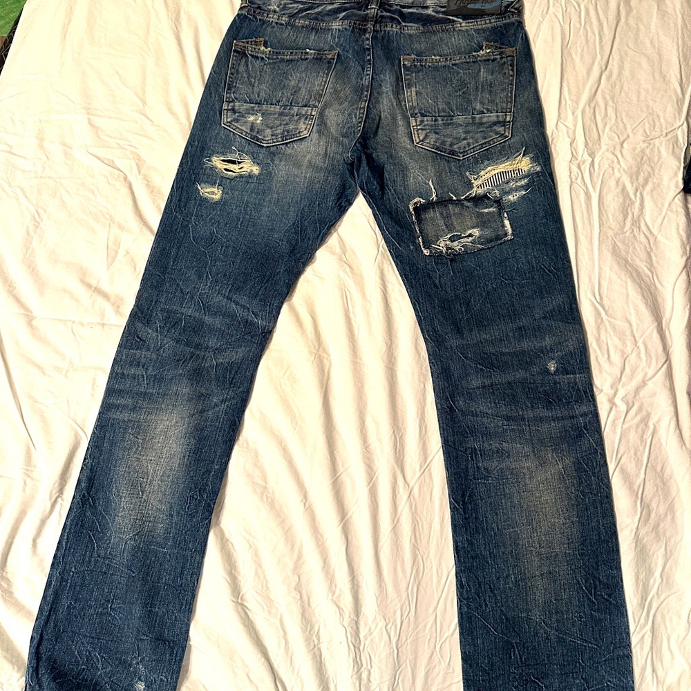 PRPS men’s jean size 34; distressed style and blue & white knee patch.